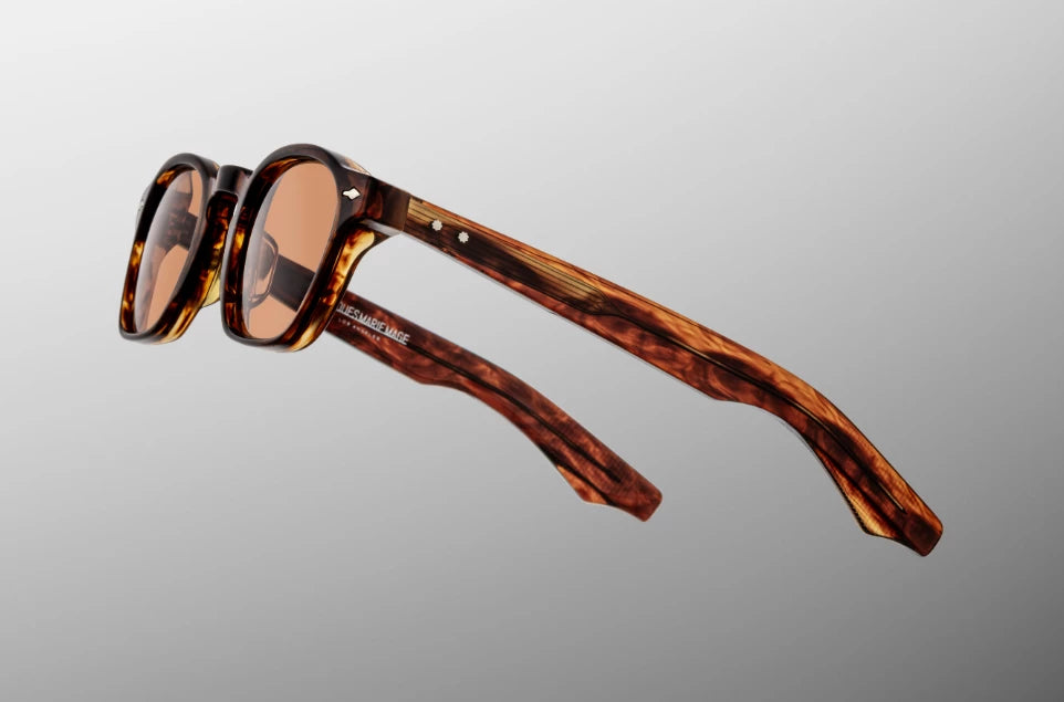 Side view of the JMM Zephirin Bourbon sunglasses temple arm, showcasing the glossy Havana double-laminated acetate construction and the signature flush sterling silver spur-shaped rivets at the hinge.