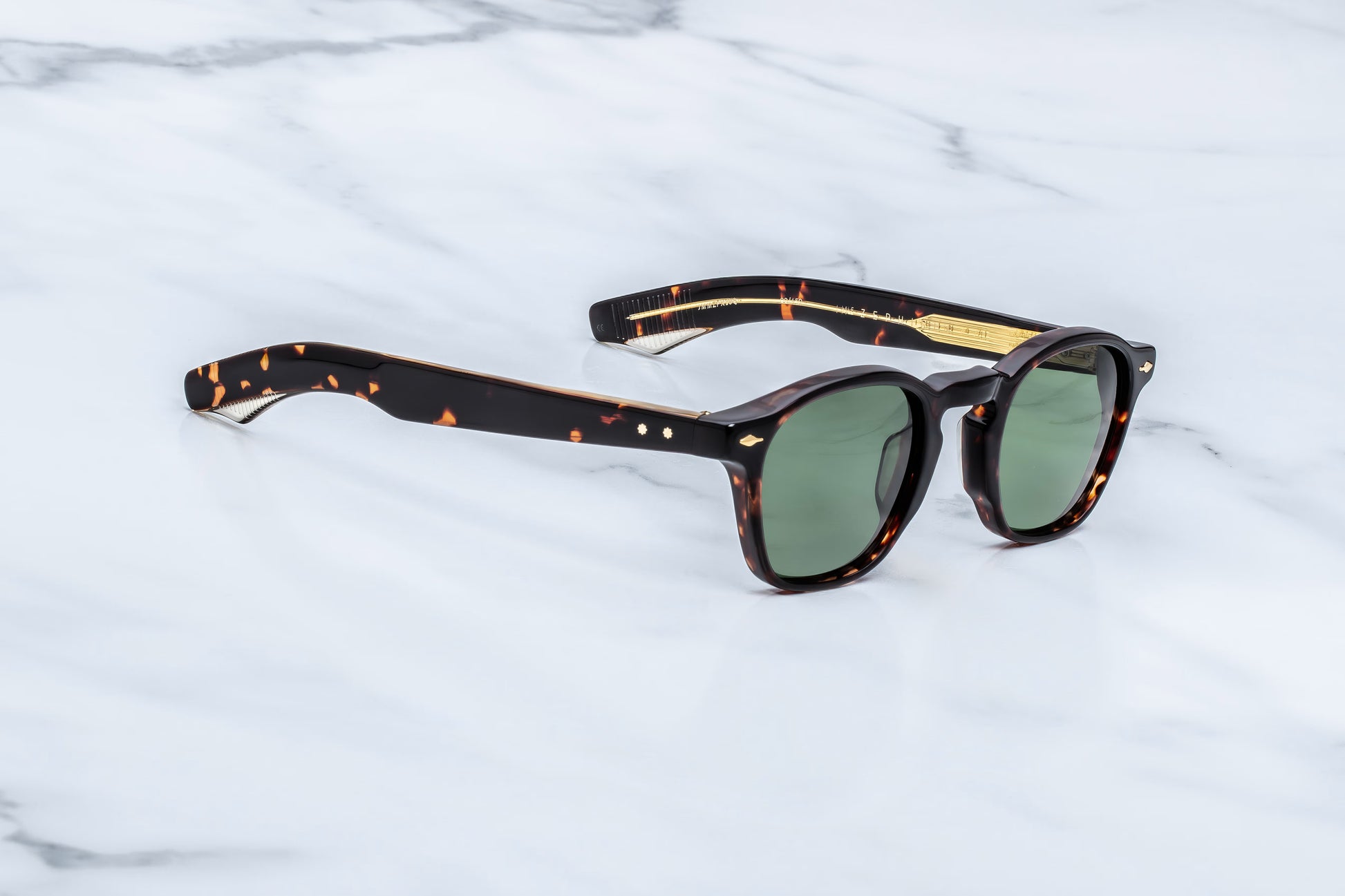 Three-quarter angled studio shot of the JMM Zephirin Etna sunglasses, highlighting the structural beveling of the thick 10mm tortoise shell frame and its classic keyhole bridge.