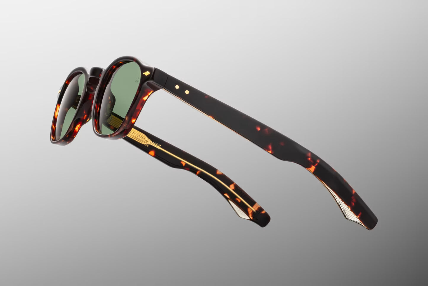Side view of the JMM Zephirin Etna sunglasses temple arm, showcasing the glossy Havana outer temple structure, dark gold spur rivets, and a glimpse of the custom inner metal core.
