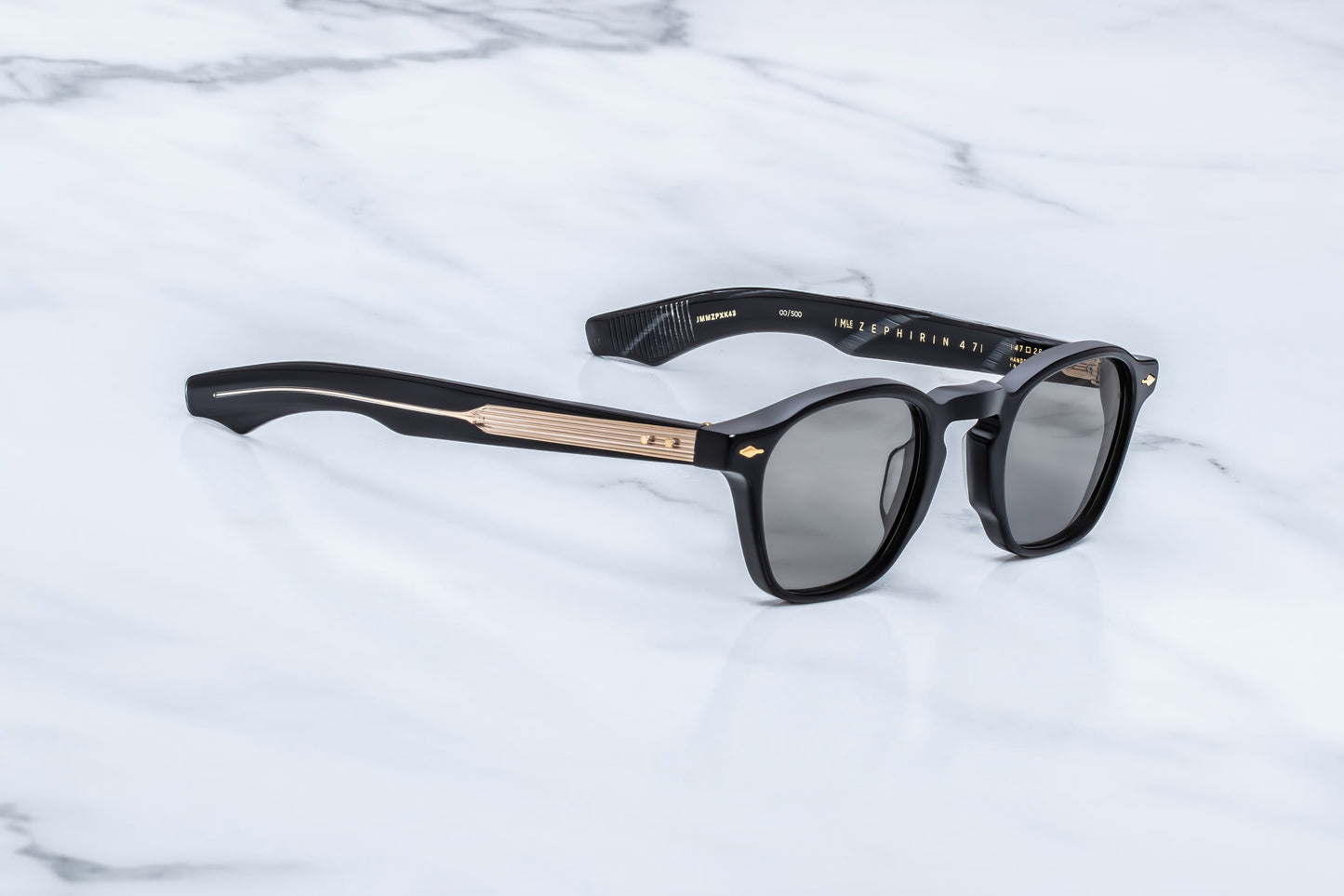 Three-quarter angled studio shot of the JMM Zephirin Griffin sunglasses, highlighting the structural beveling of the thick 10mm black block frame and its classic retro keyhole bridge.