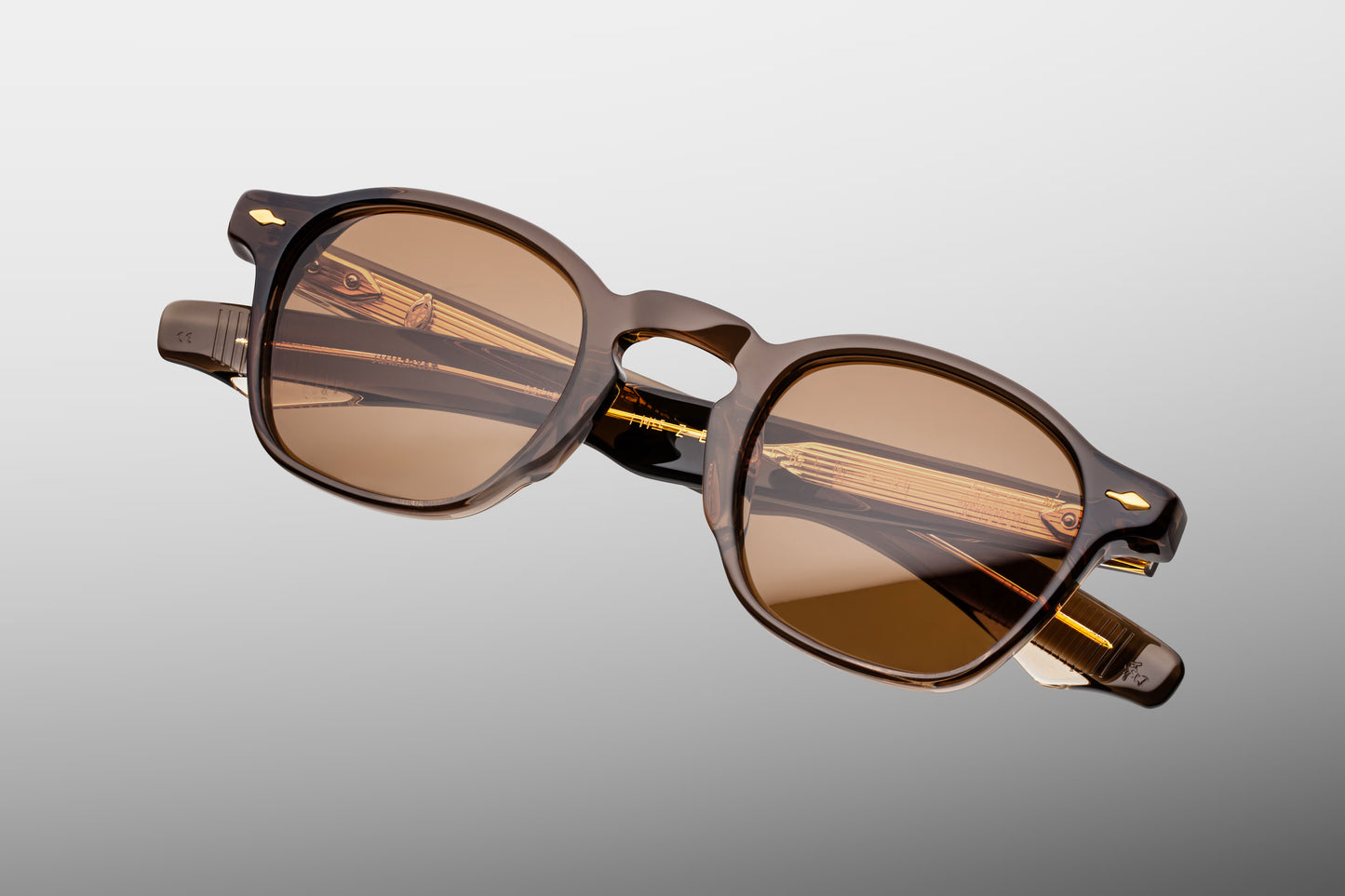 Top-down view of the JMM Zephirin London frame, revealing the top-line profile of the substantial brown acetate brow line, sculpted nose contours, and custom light gold 5-barrel hinges.
