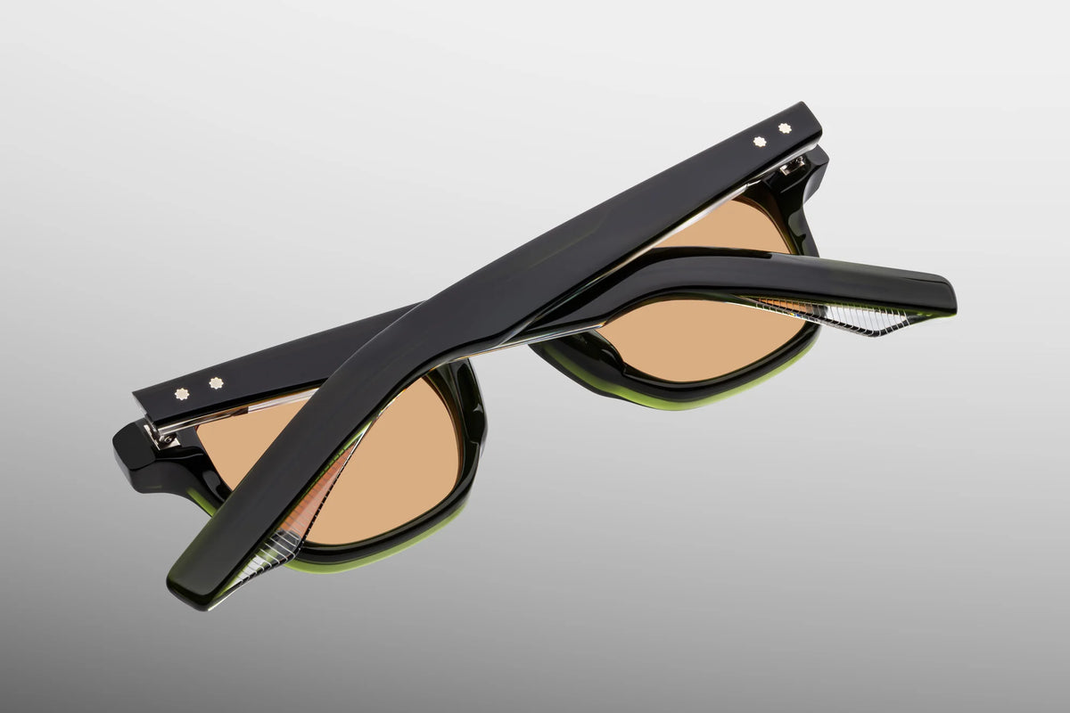 Three-quarter rear view of the folded Jacques Marie Mage Zephirin 47 Borneo sunglasses, highlighting the stacked profile of the thick green acetate temples and the signature inner metal core detailing