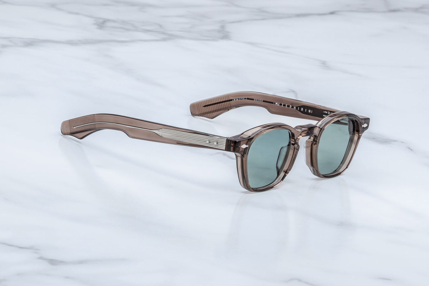 Side profile of Jacques Marie Mage Zephirin Dusty Jade sunglasses showcasing sculpted temples, custom metal hinges, and translucent dusty jade green acetate construction