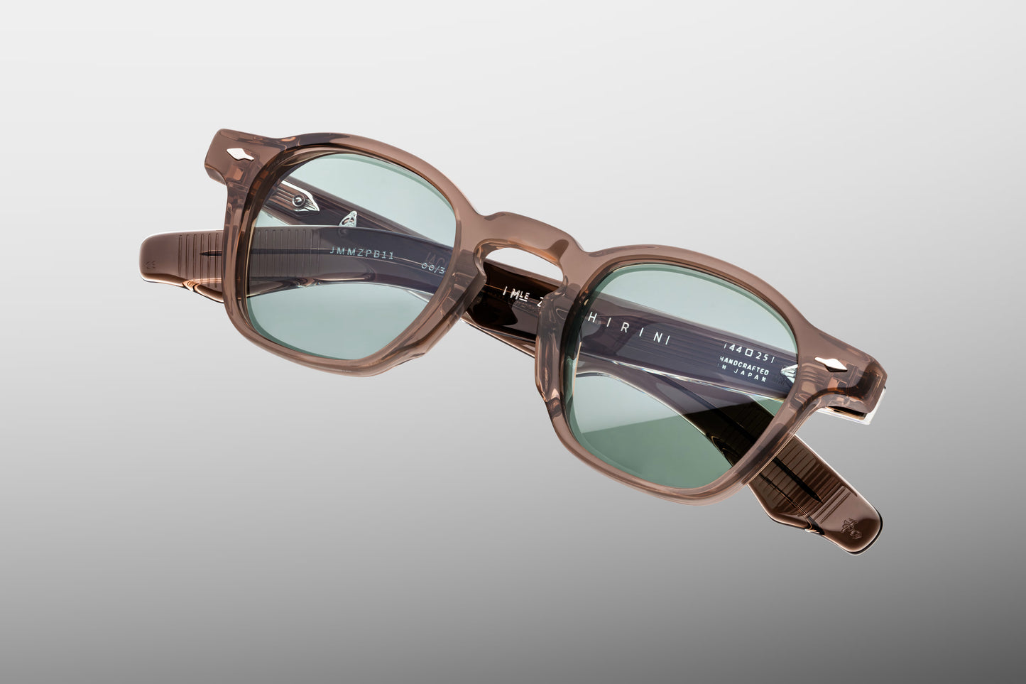 Close-up front detail of Jacques Marie Mage Zephirin Dusty Jade sunglasses showing precision-cut lenses, polished acetate surface, and bold geometric frame lines