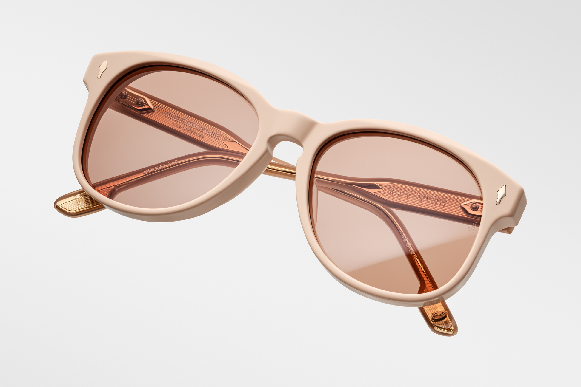 Three-quarter angle of Jacques Marie Mage Kay in dust suede showing softly rounded frame and light brown lenses