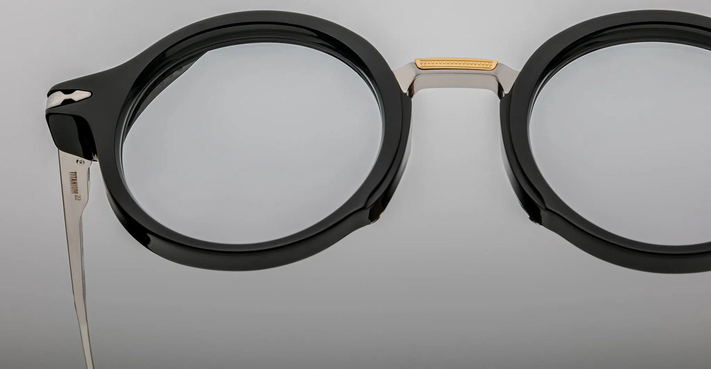 Macro view of the Jacques Marie Mage Norman noir bridge, revealing sculpted acetate surfaces paired with refined metal engineering with silver and dark gold metal deailing