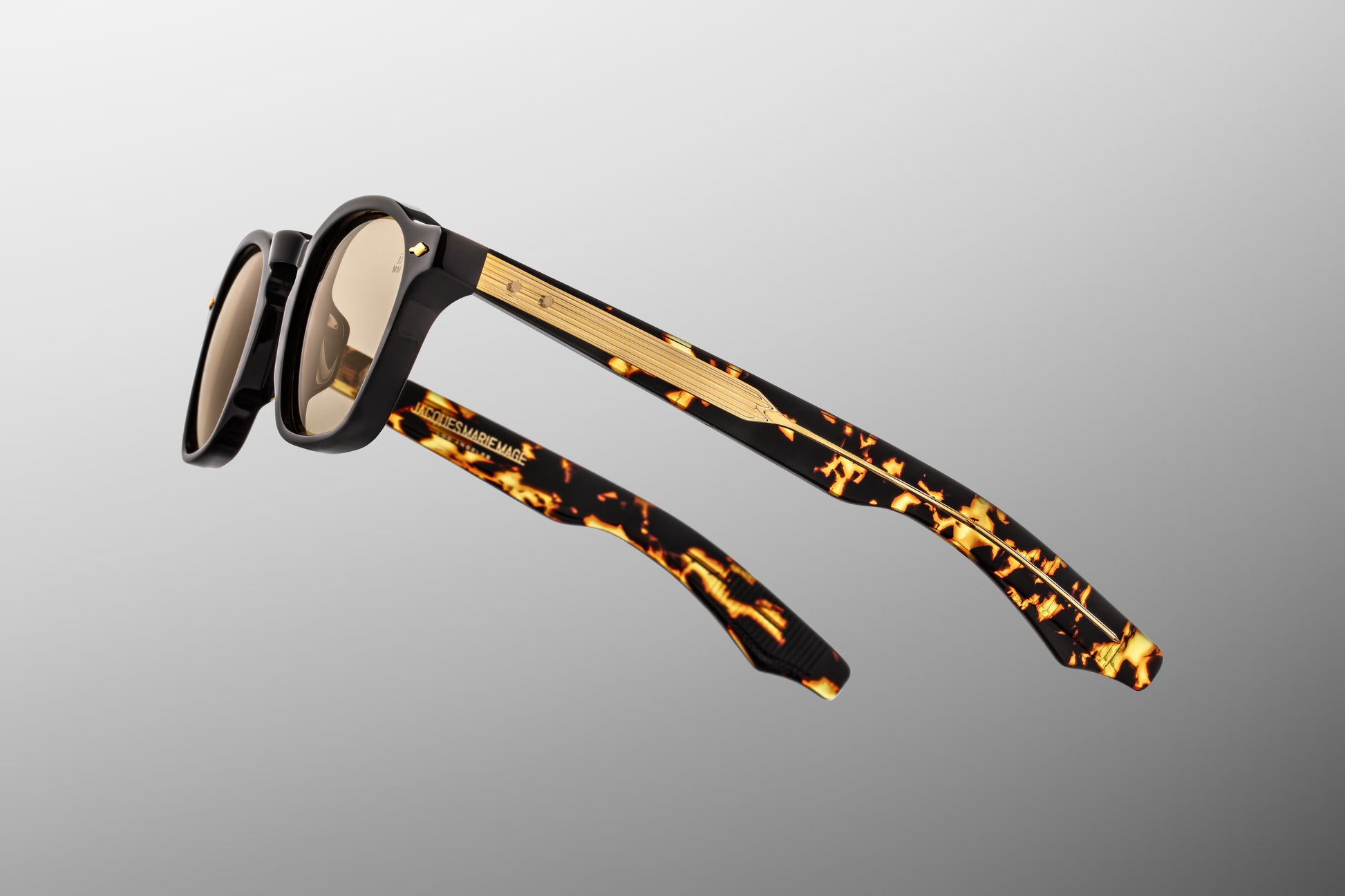 Close-up side detail of Jacques Marie Mage Zephirin Tavern showing engraved gold wire core, hinge construction and temple design
Macro side view of JMM Zephirin Tavern sunglasses highlighting premium hardware and acetate layering