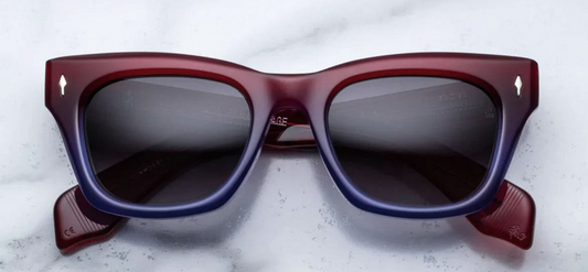 Jacques Marie Mage Dealan sunglasses in Vesper, featuring a flared square frame crafted from 10mm cured cellulose acetate in a red-to-blue gradient. The design includes custom double-laminated acetate temples, silver arrowhead front pins, and tension-secured monoblock hinges. The jet gradient CR39 lenses offer 100% UV protection and backside anti-reflective treatment. Handcrafted in Japan, this limited-edition model is part of a 350-piece production run, combining bold volumes and sleek line