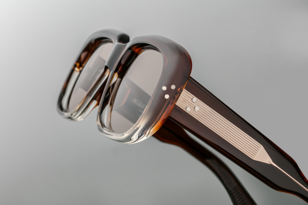 Side view of Jacques Marie Mage Kobo sunglasses in Hickory Fade, showcasing sculpted double-laminated acetate temples with intricate Native American-inspired engravings along an exposed dark gold wirecore, and a signature dark gold arrowhead front pin.