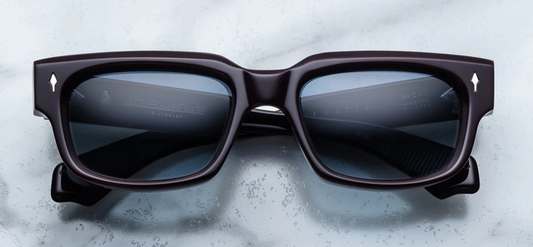 Refined, 1960s-inspired rectangular eyeglasses by Jacques Marie Mage, model Mattei in Wine. Features a purple acetate frame with sculptural temples, silver metal detailing, blue gradient lenses, and signature arrowhead pin. Includes custom hardware and offers 100% UV protection. Available at WINK Optometrists.