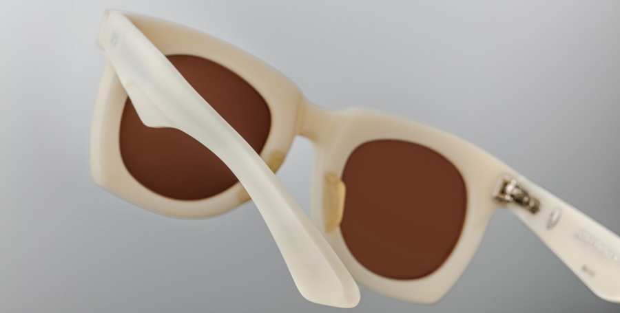 The ‘Ava’ is a sleek '50s inspired glasses with graceful lines, signature double-arrowhead front pins, and custom double-laminated temples with refined 'Lever' wire core. White 8mm cured cellulose acetate frame with custom double laminated acetate temples featuring precious metal hardware and primary brown lenses. Limited edition of 150 pieces. Handcrafted in Japan. Size 45/24. 