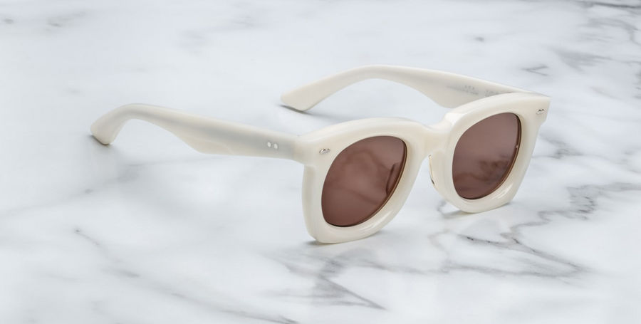 The ‘Ava’ is a sleek '50s inspired glasses with graceful lines, signature double-arrowhead front pins, and custom double-laminated temples with refined 'Lever' wire core. White 8mm cured cellulose acetate frame with custom double laminated acetate temples featuring precious metal hardware and primary brown lenses. Limited edition of 150 pieces. Handcrafted in Japan. Size 45/24. 