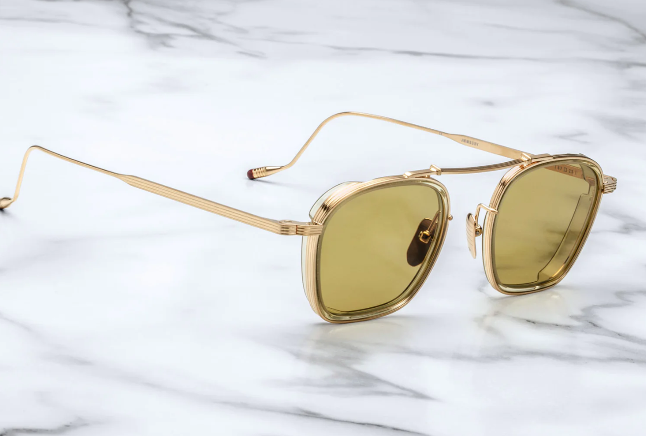 Clean and sophisticated, the Baudelaire shades mix titanium frames and acetate lens rims, with subtle flourishes of sculptural details that are poetic and timeless. GOLD 100% BETA TITANIUM FRAME WITH CUSTOM TEMPLE TIPS AND GREEN LENSES. Limited batch of 350 pieces. Handcrafted in Japan. Size 47/23.