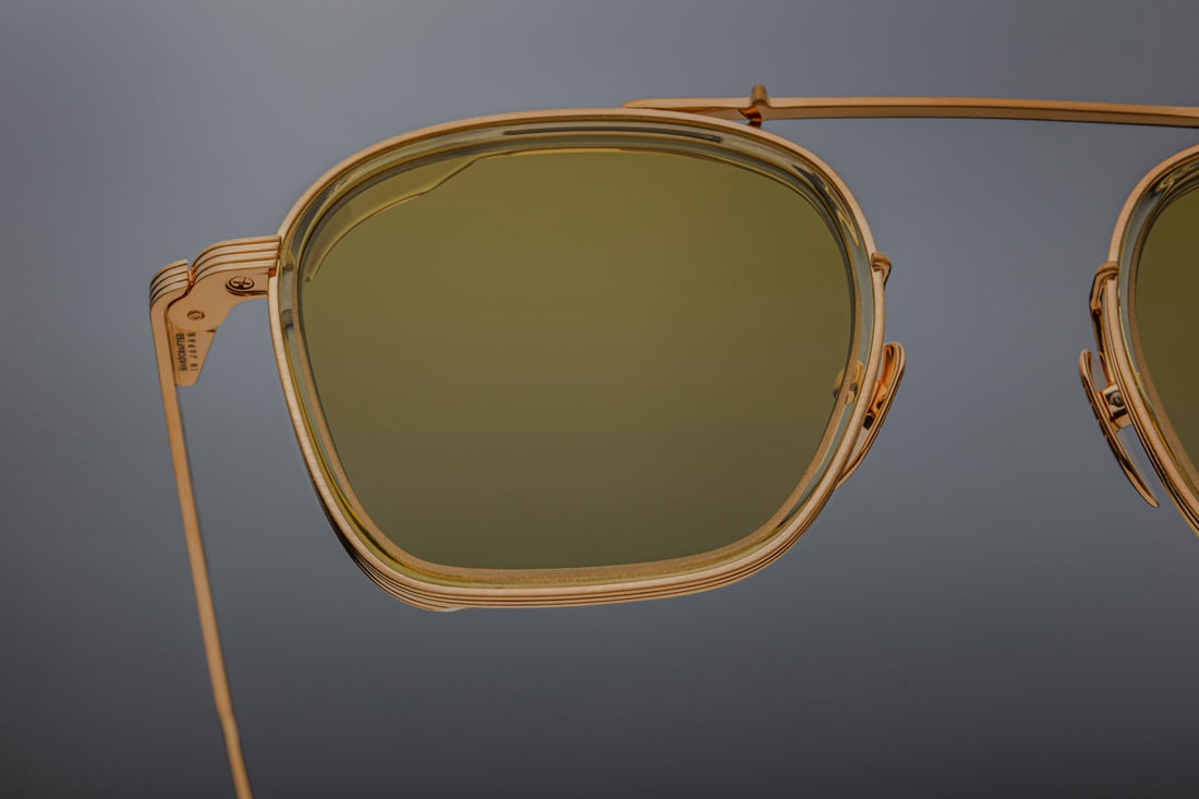 Clean and sophisticated, the Baudelaire shades mix titanium frames and acetate lens rims, with subtle flourishes of sculptural details that are poetic and timeless. GOLD 100% BETA TITANIUM FRAME WITH CUSTOM TEMPLE TIPS AND GREEN LENSES. Limited batch of 350 pieces. Handcrafted in Japan. Size 47/23.