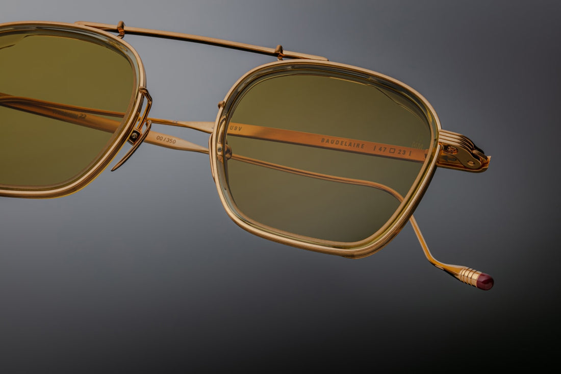 Clean and sophisticated, the Baudelaire shades mix titanium frames and acetate lens rims, with subtle flourishes of sculptural details that are poetic and timeless. GOLD 100% BETA TITANIUM FRAME WITH CUSTOM TEMPLE TIPS AND GREEN LENSES. Limited batch of 350 pieces. Handcrafted in Japan. Size 47/23.