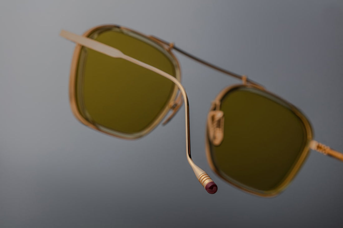 Clean and sophisticated, the Baudelaire shades mix titanium frames and acetate lens rims, with subtle flourishes of sculptural details that are poetic and timeless. GOLD 100% BETA TITANIUM FRAME WITH CUSTOM TEMPLE TIPS AND GREEN LENSES. Limited batch of 350 pieces. Handcrafted in Japan. Size 47/23.